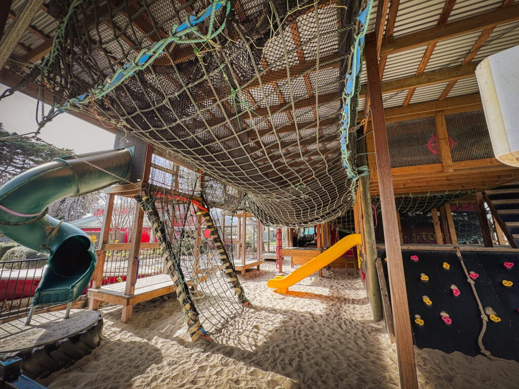 Inside the playground. You can see the rope nets, slide and climbing walls that are part of the adventure playground. It's all set up upon a huge sand pit.